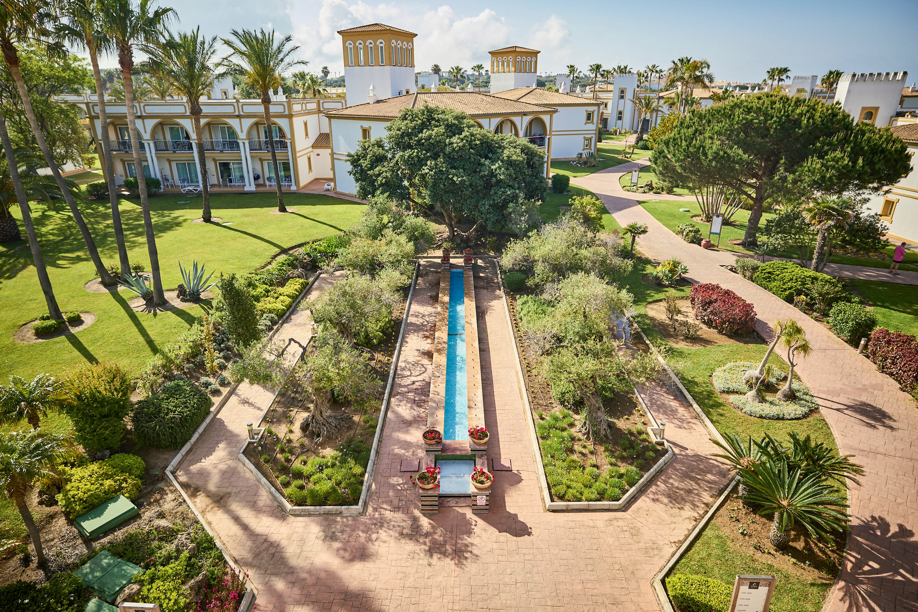 Aldiana Premium Cluburlaub: Mediterraner Garten mit Wasserlauf und Palmen, gepflegte Wege