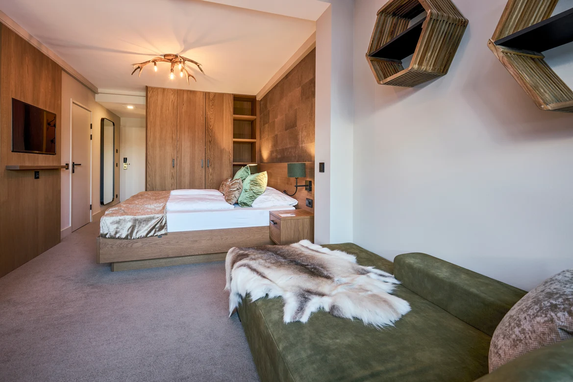 Doppelbett im modernen Hotelzimmer von Aldiana mit Holzdekor und gemütlicher Atmosphäre