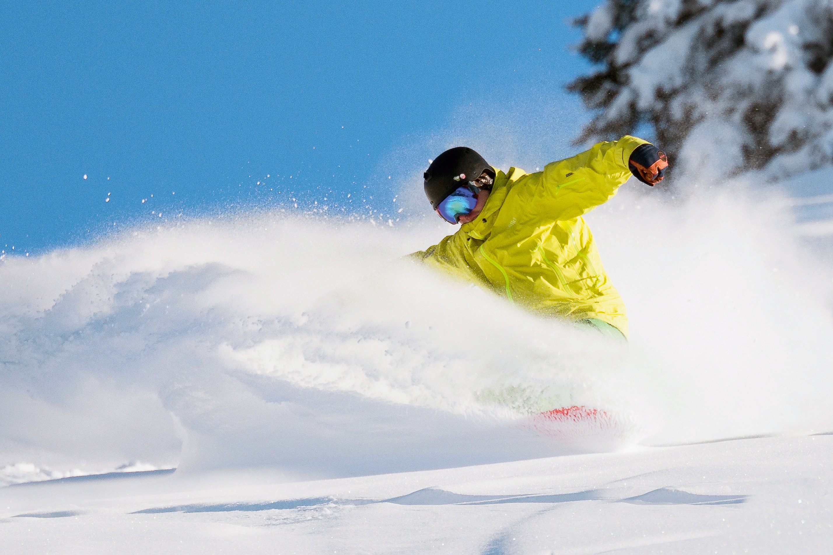 Skifahrer in gelber Jacke beim Skifahren auf verschneiter Piste, Winterurlaub bei Aldiana
