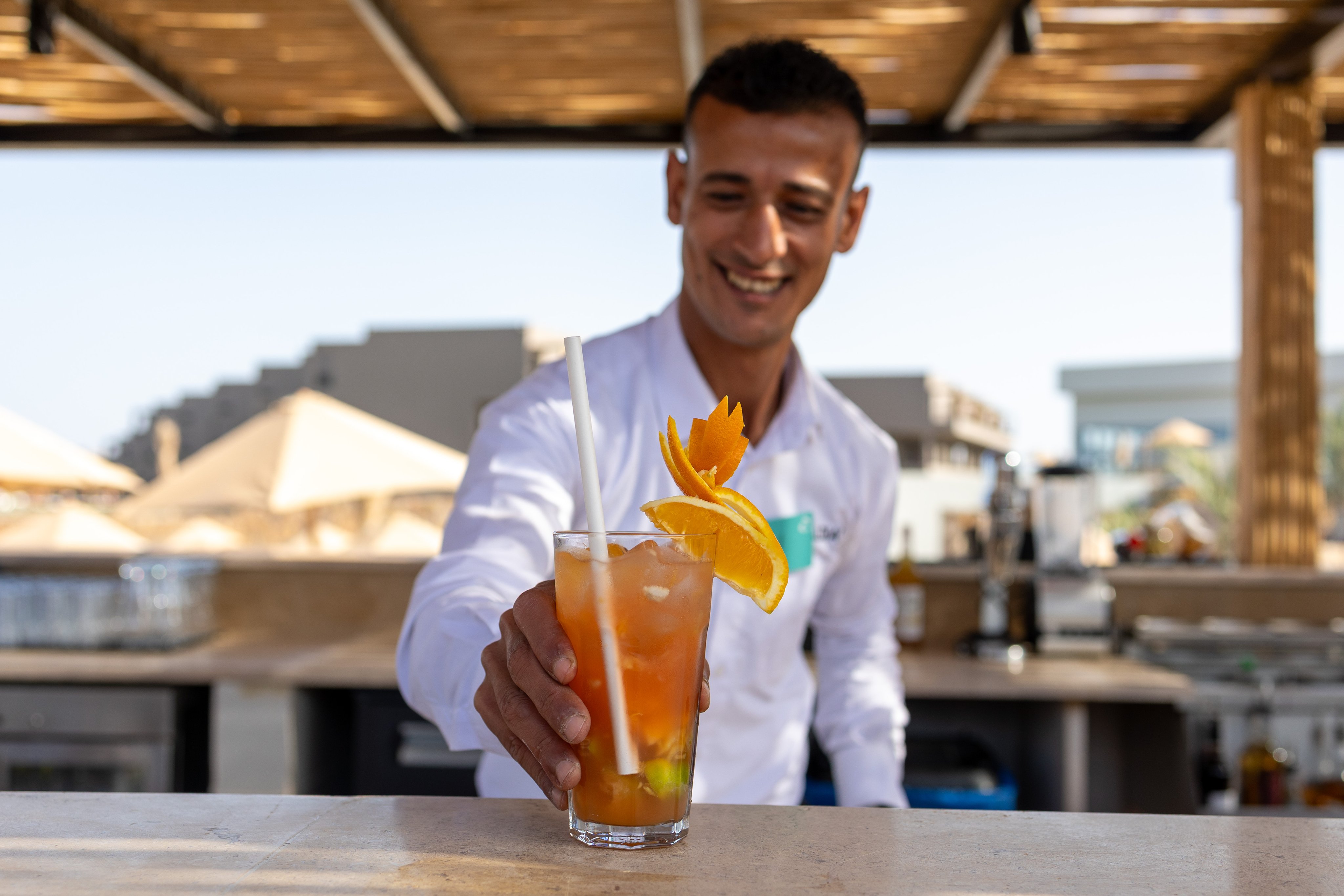 Ein Mann hält einen tropischen Cocktail an einem Aldiana Premium Cluburlaub Standort