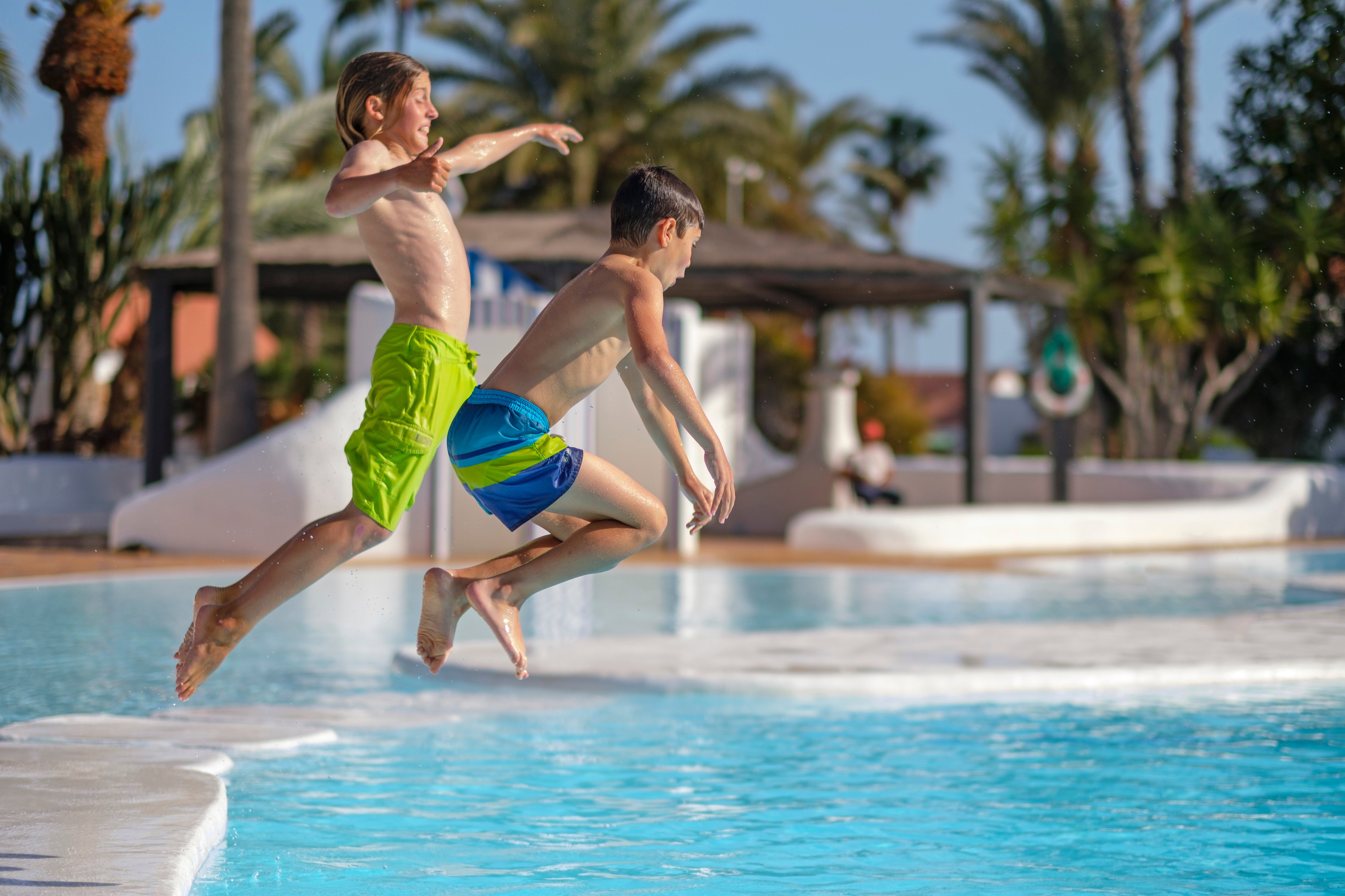 Zwei Kinder springen ins Pool bei einem Aldiana Premium Cluburlaub