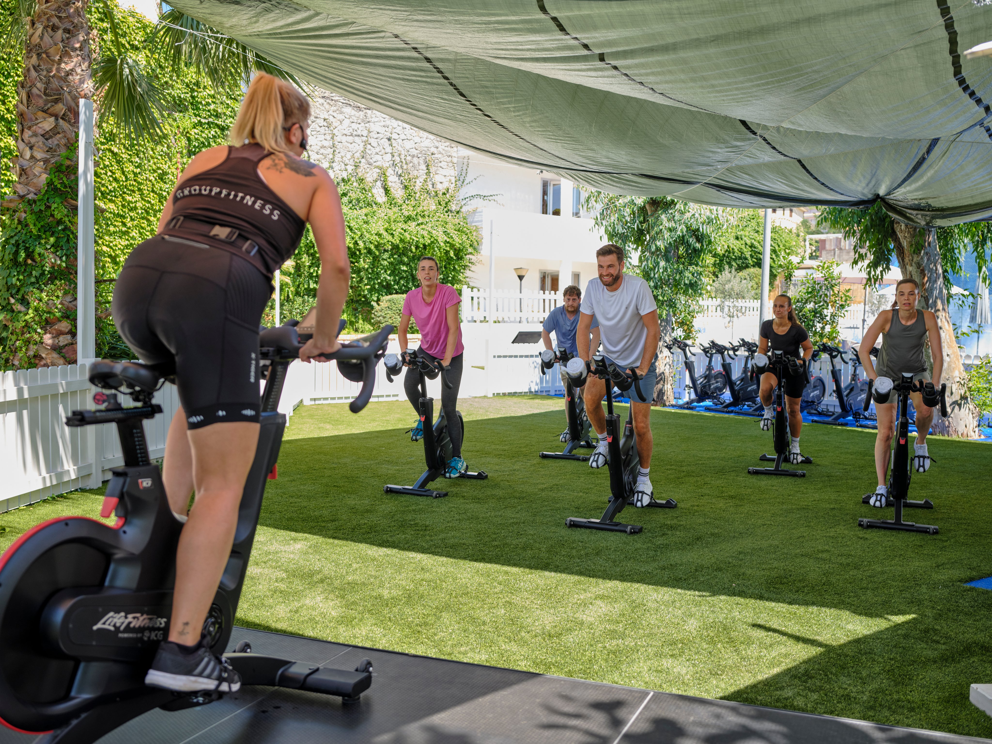Mehrere Menschen trainieren auf einem Outdoor Fitnessplatz im Grünen bei Aldiana Premium Cluburlaub