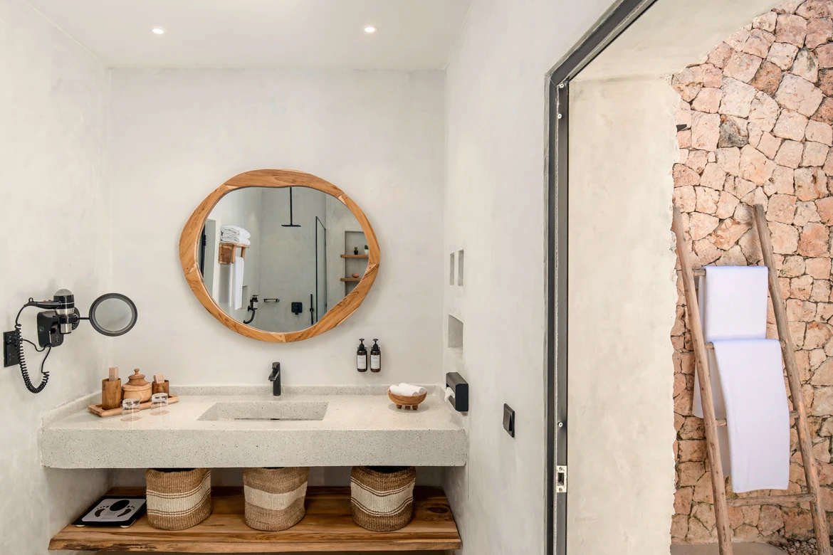 Ein modernes Badezimmer mit Spiegel, Waschbecken und dekorativen Elementen im Premium Cluburlaub von Aldiana