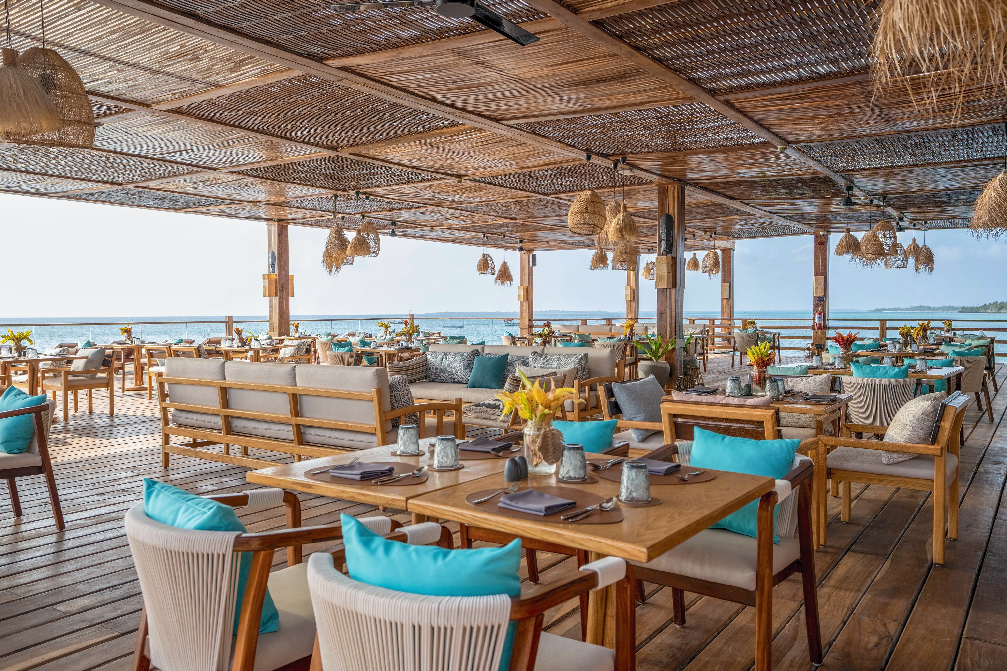 Gemütliches Strandrestaurant bei Sonnenuntergang mit Blick auf das Meer, elegante Einrichtung