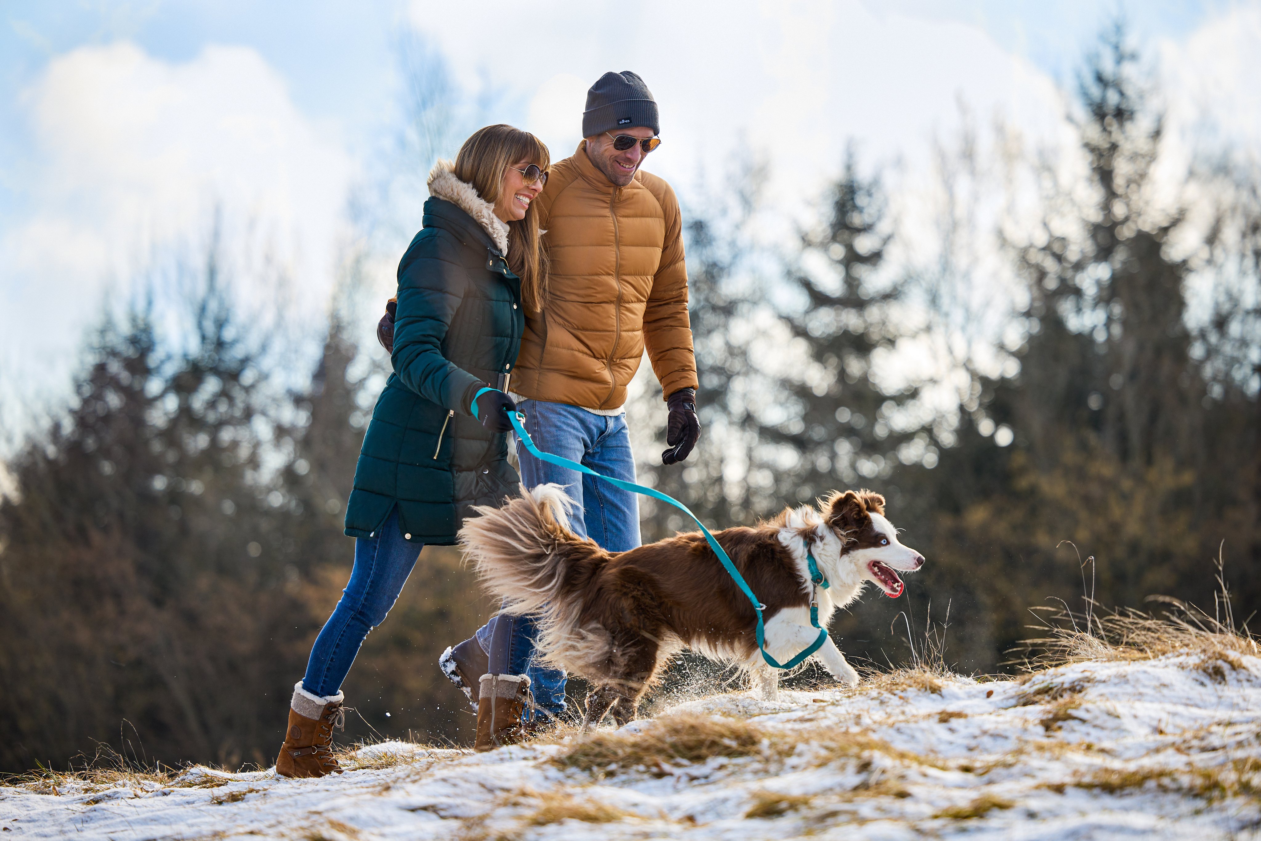 Zwei Personen mit Hund beim Spaziergang im Winter, genießen die Natur bei Aldiana.