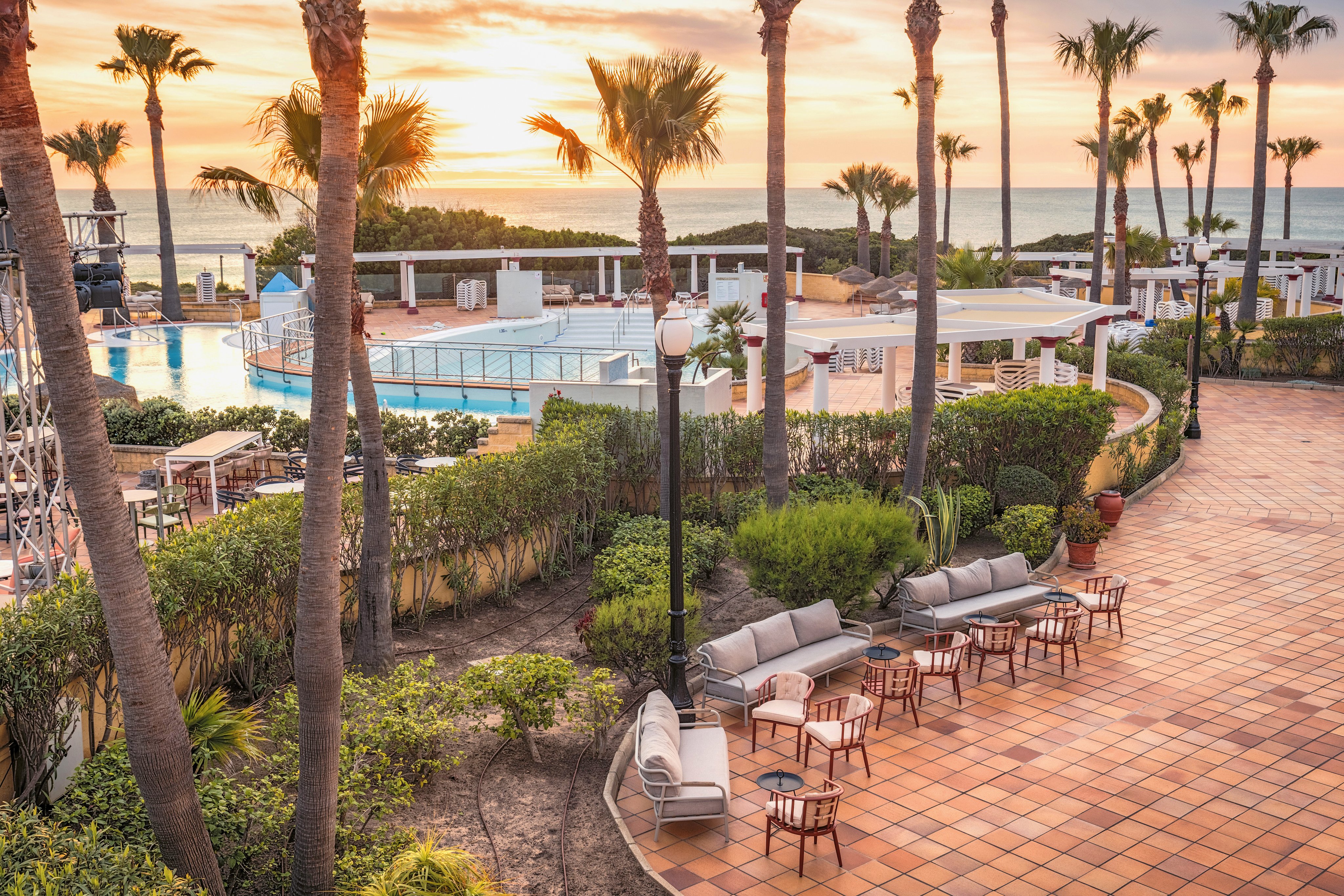 Luxusclubhotel bei Sonnenuntergang mit Pool und Palmen, ideal für Premium Cluburlaub bei Aldiana