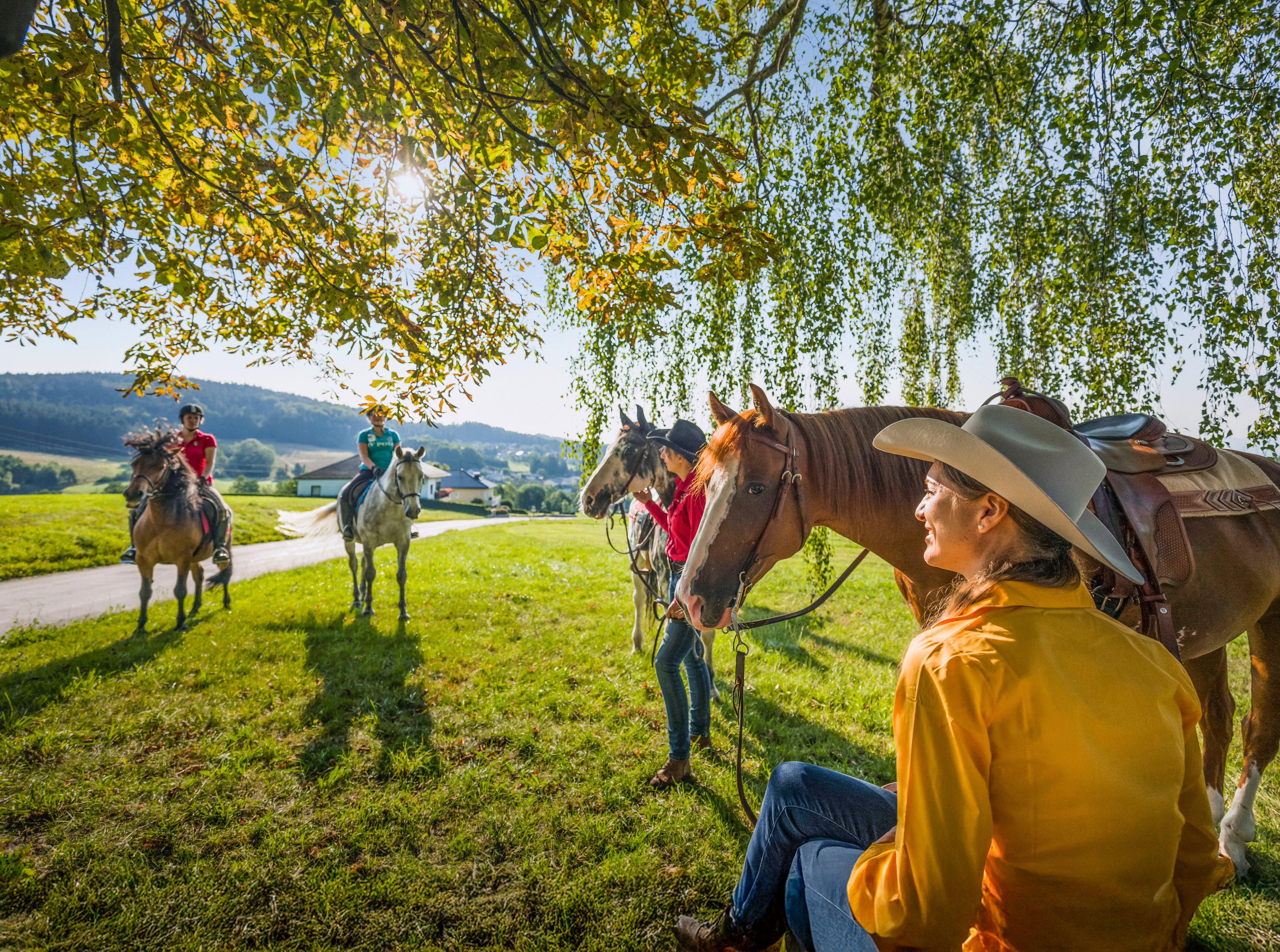 Menschen beim Ausritt im Grünen, genießen einen sonnigen Tag im Premium Cluburlaub