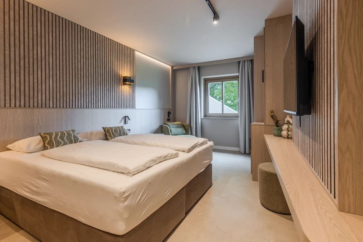 Angenehmes Hotelzimmer bei Aldiana mit Doppelbett, Sofa und Fenster für Premium Cluburlaub