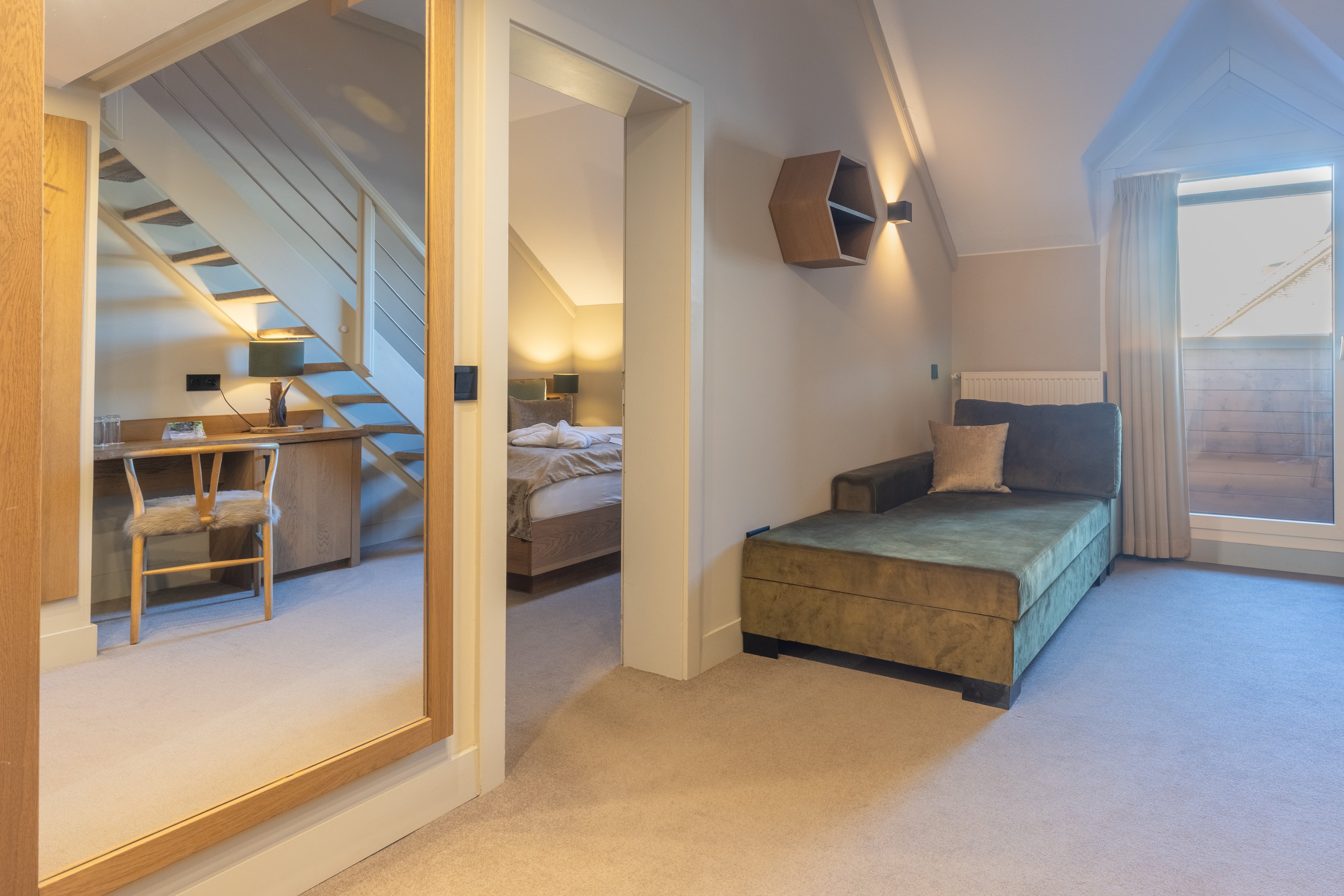 Moderne Suite mit Bett, Sitzecke und Blick auf Terrasse im Aldiana Premium Cluburlaub