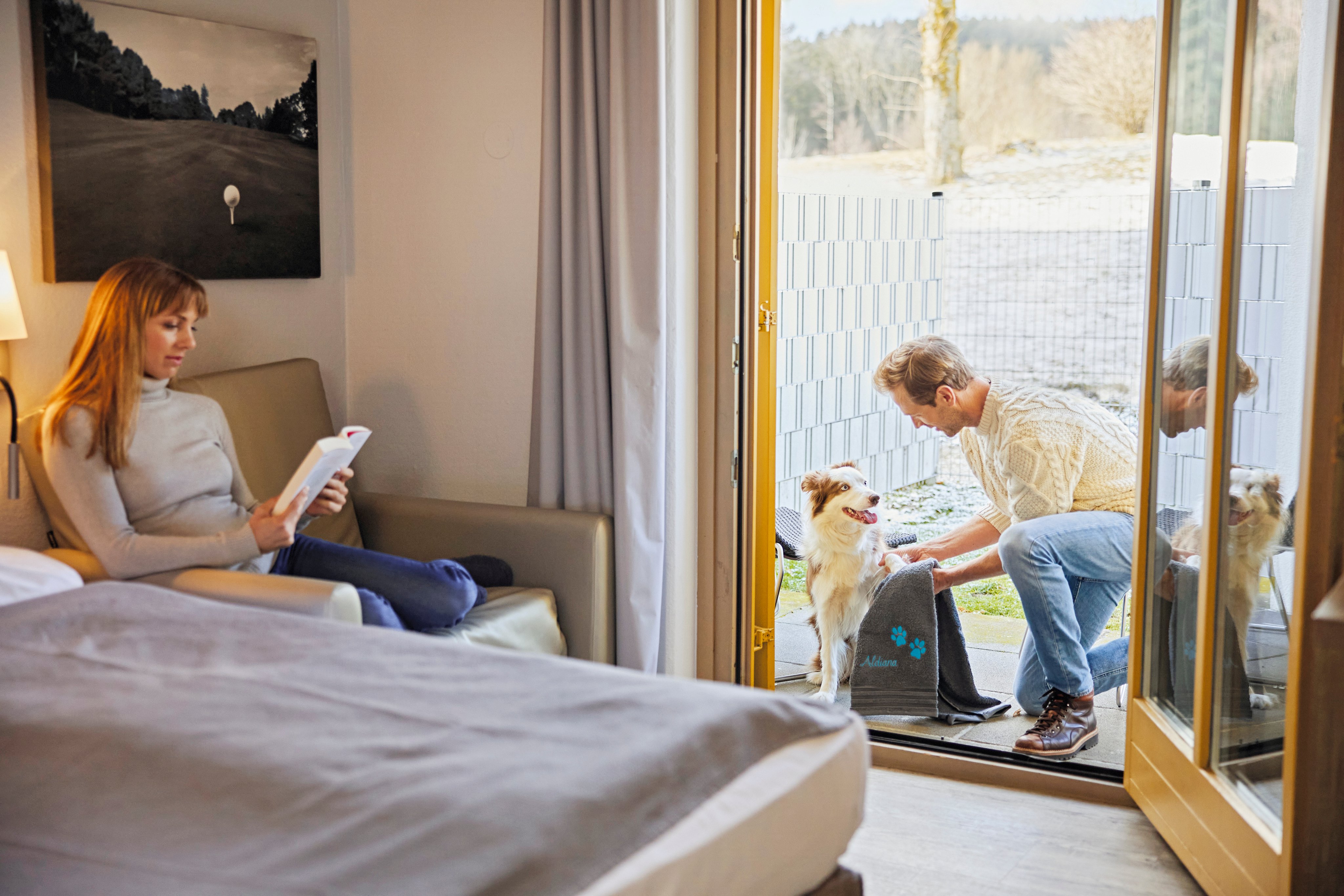 Familie im Wohnzimmer, Hund draußen auf der Terrasse, entspannt und glücklich bei Aldiana Premium Urlaub