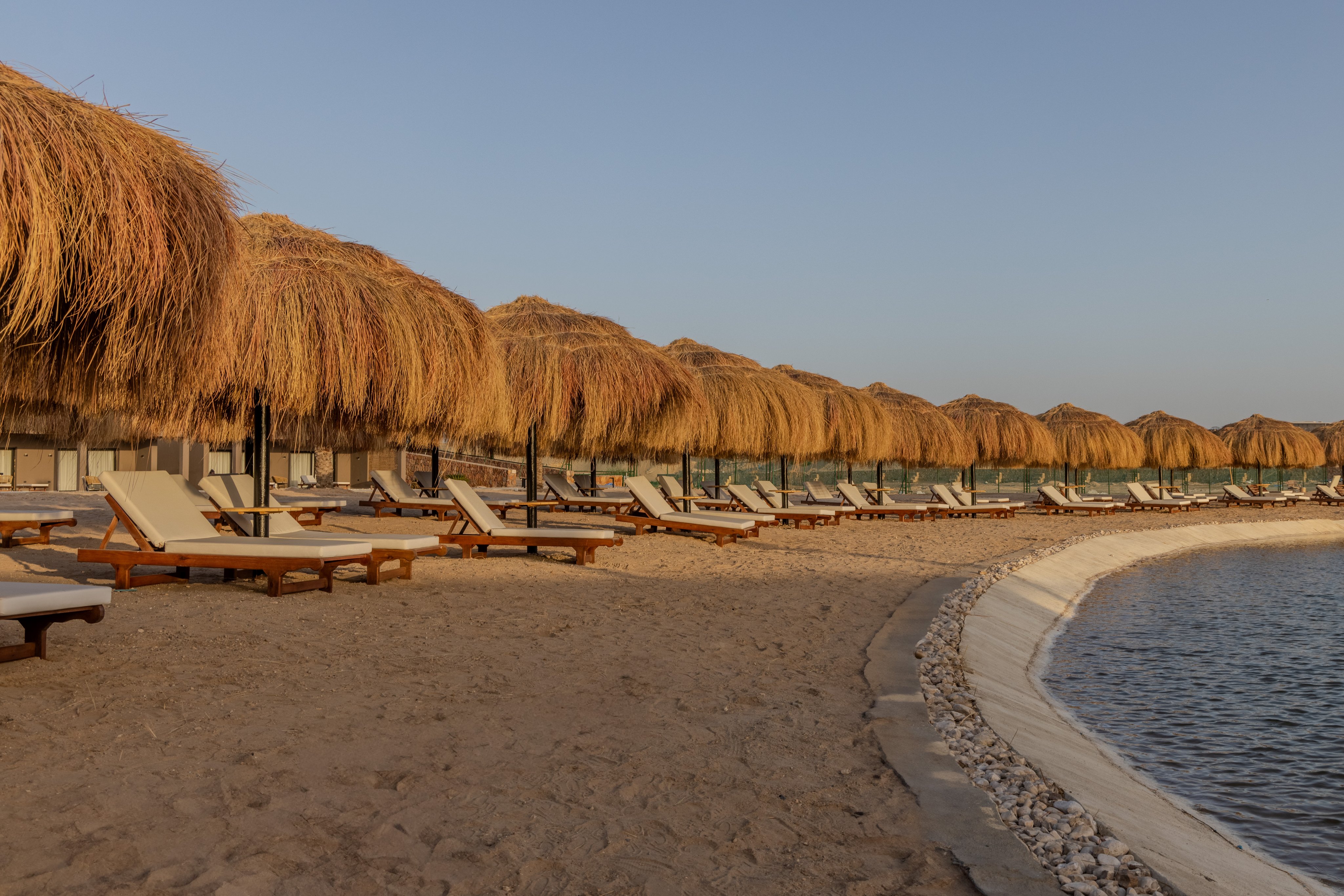 Entspannung am Strand bei Aldiana mit Sonnenschirmen und Liegen.