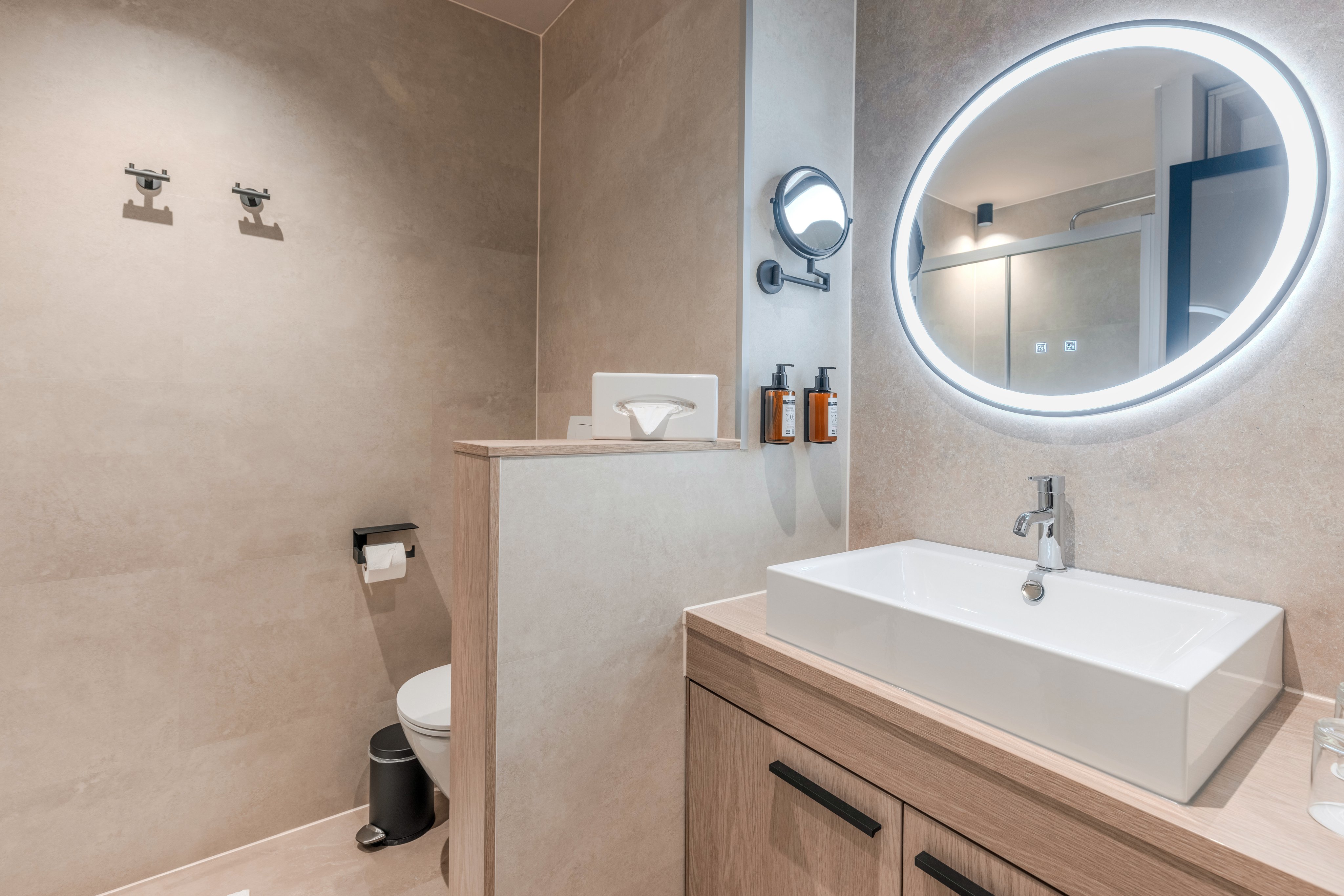 现代 Badezimmer mit Wandspiegel, Waschbecken und Toilette im eleganten Aldiana Style