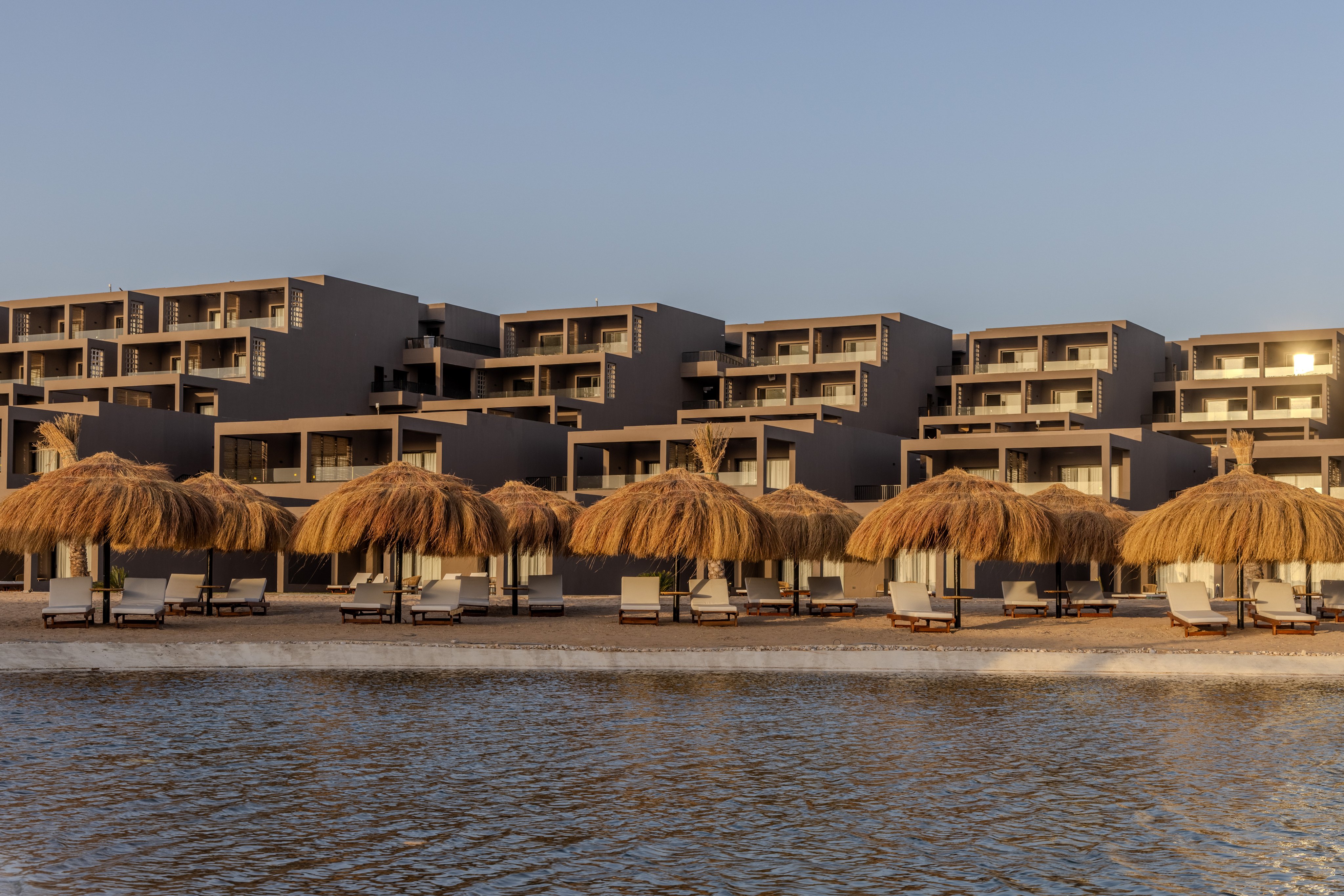 Aldiana Ferienanlage am Strand mit Sonnenschirmen und Liegestühlen am Wasser.