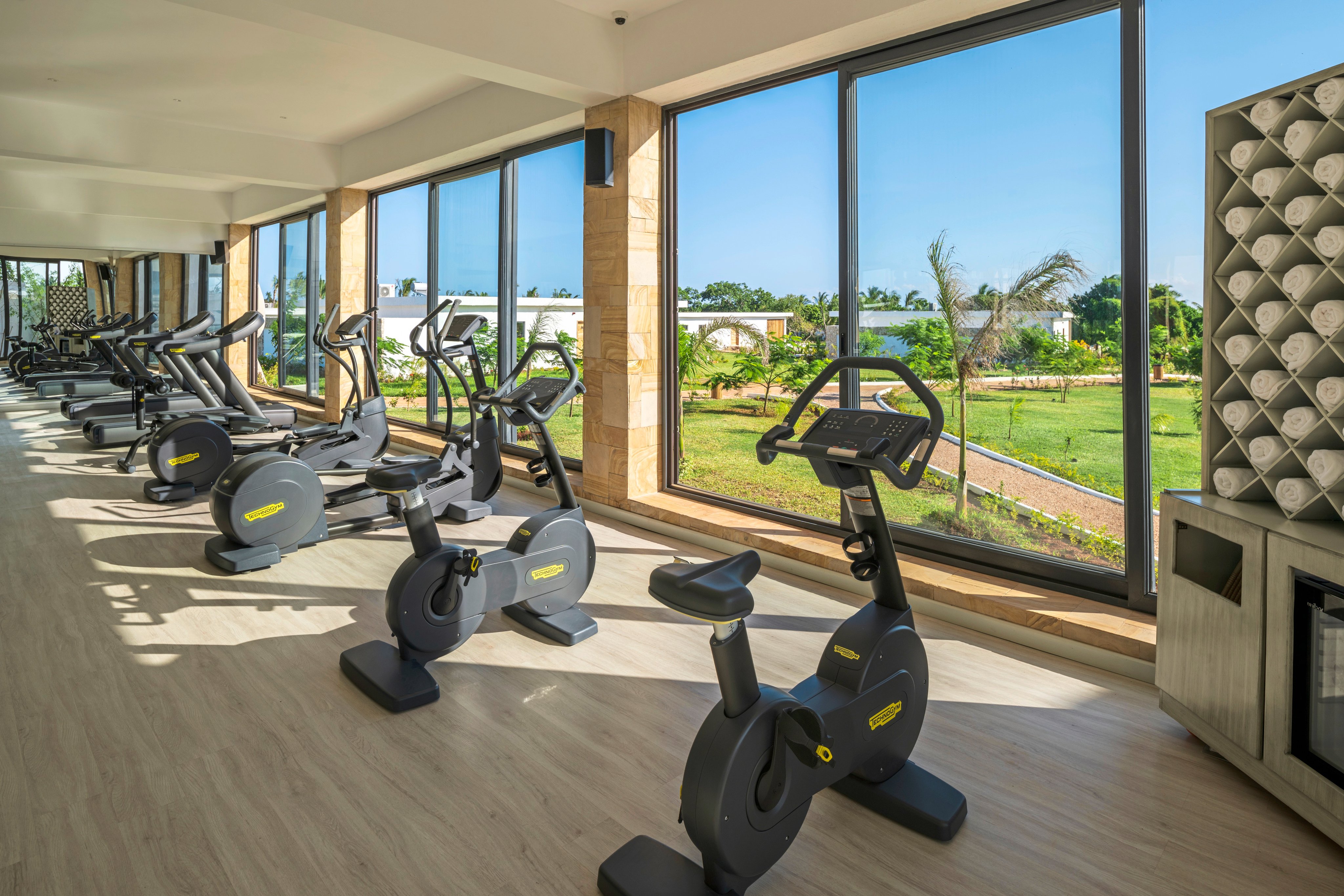 Modernes Fitnessstudio bei Aldiana mit Laufbändern und Fitnessgeräten, große Fenster mit Blick nach draußen