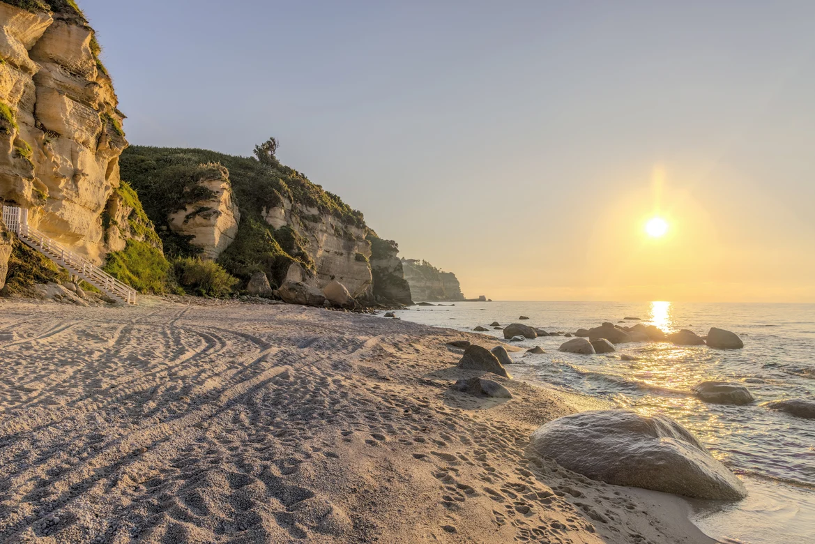 Strand bei Sonnenuntergang auf einer Klippe mit Blick aufs Meer, ideal für Premium Cluburlaub