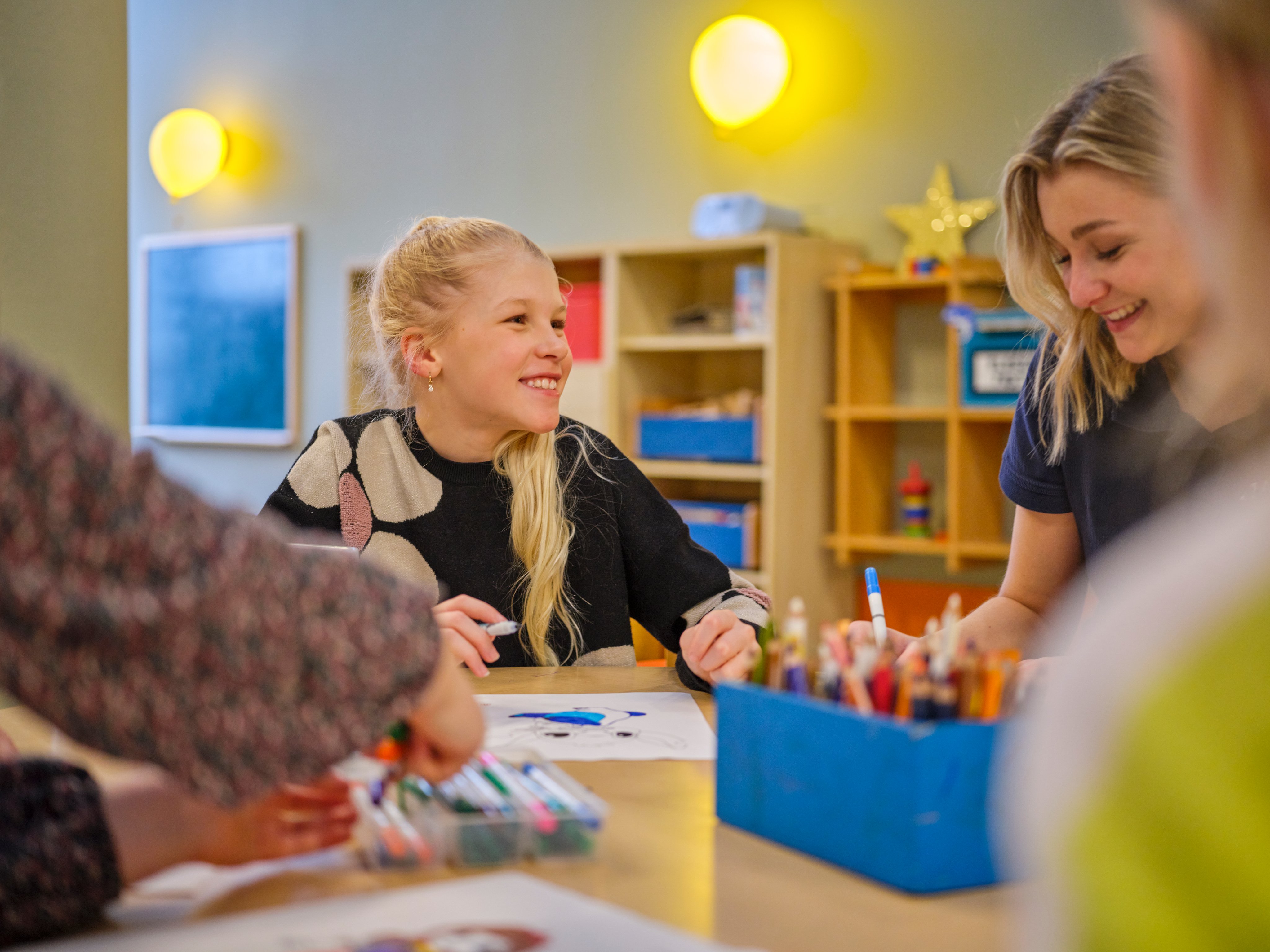 Kinder spielen in einem Raum bei einer Aktivität mit Bastelmaterialien, komfortive Lernumgebung