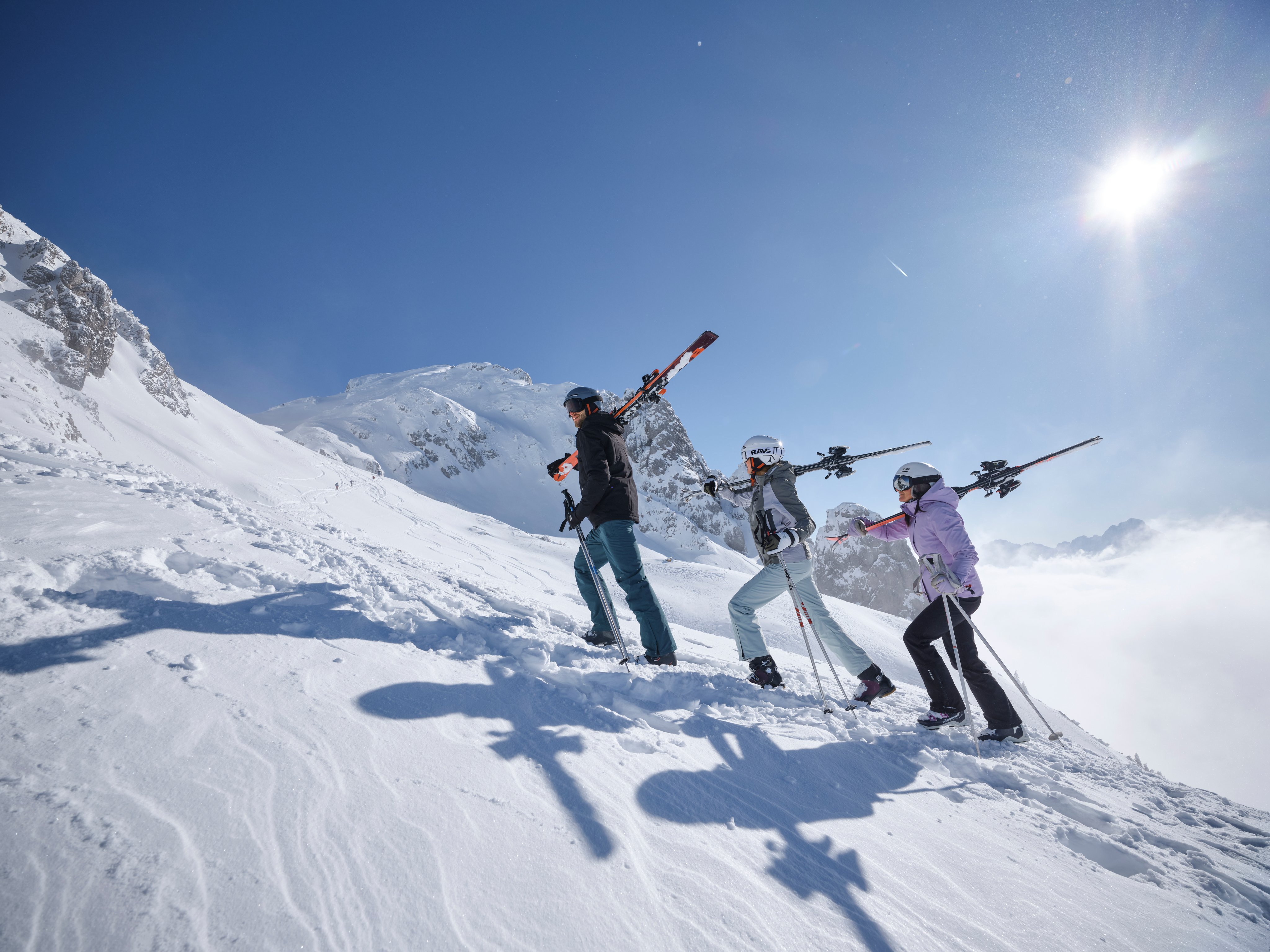 Gruppe beim Skifahren in verschneiter Berglandschaft, Sonnenschein, winterliches Erlebnis