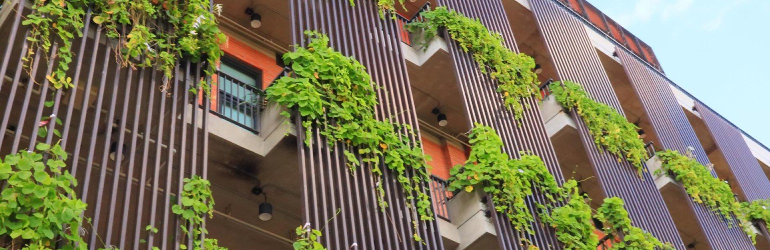 Fassade der Basellandschaftlichen Kantonalbank (BLKB) mit grünen Pflanzen und moderner Architektur.