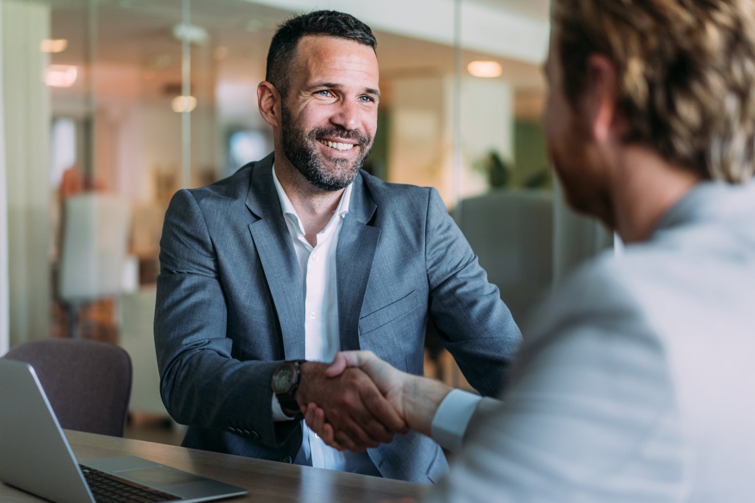 Zwei Geschäftspartner bei einem Meeting in einem modernen Büro. aus dem Artikel Kaufen oder verkaufen? Mit der BLKB-Firmenbörse zum passenden Match.