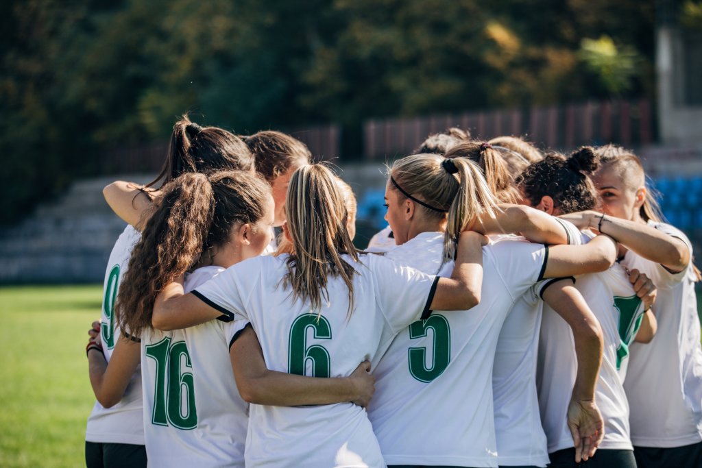 Gruppe von Frauen, Frauenfußballmannschaft feiert den Sieg auf dem Fußballfeld.