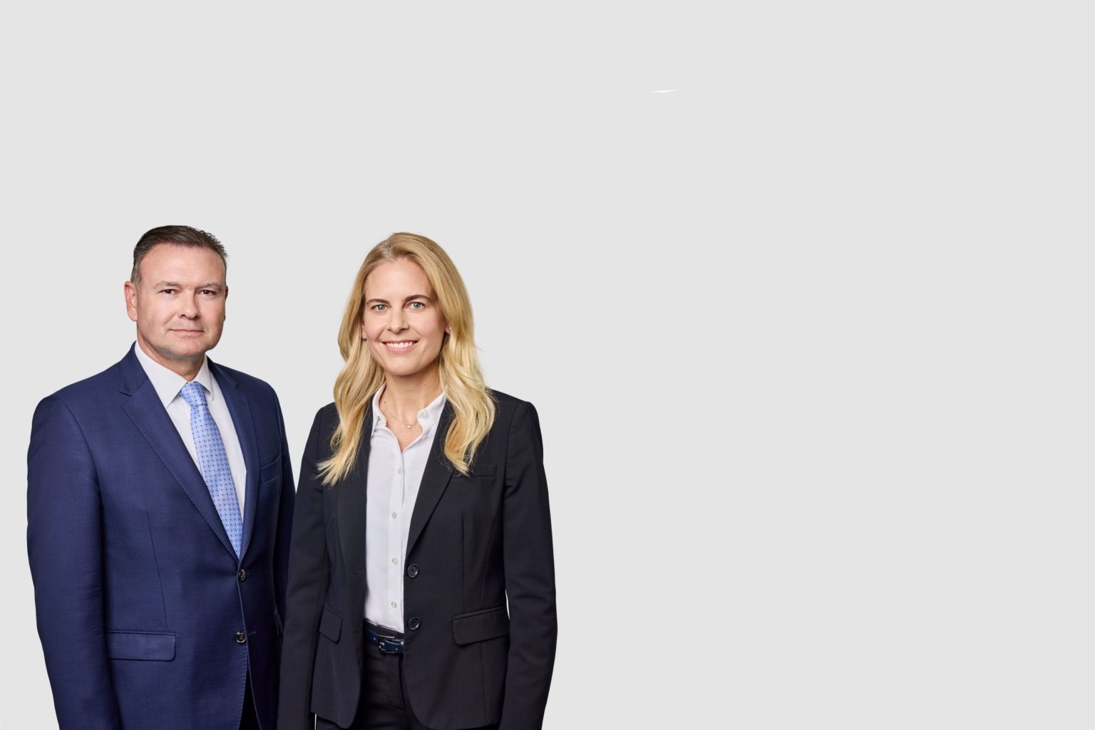 Thomas Aegerter und Alexandra Scriba in formeller Kleidung vor neutralem Hintergrund.