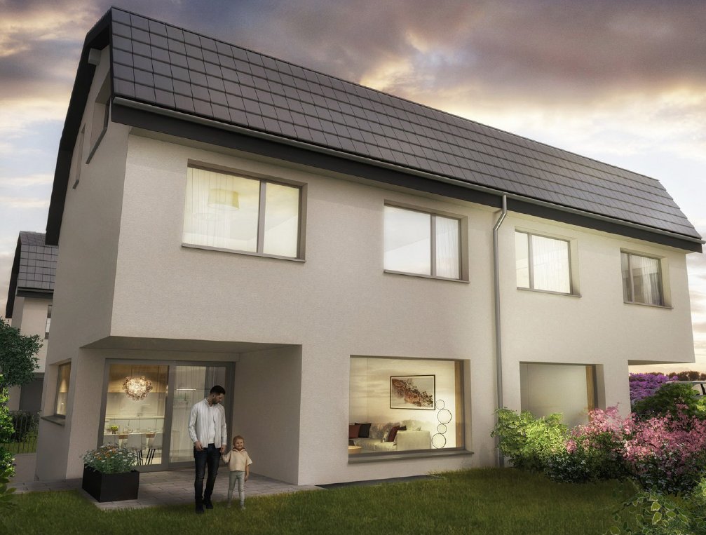 Ein modernes zweigeschossiges Haus mit großen Fenstern und einem angelegten Garten in der Dämmerung.