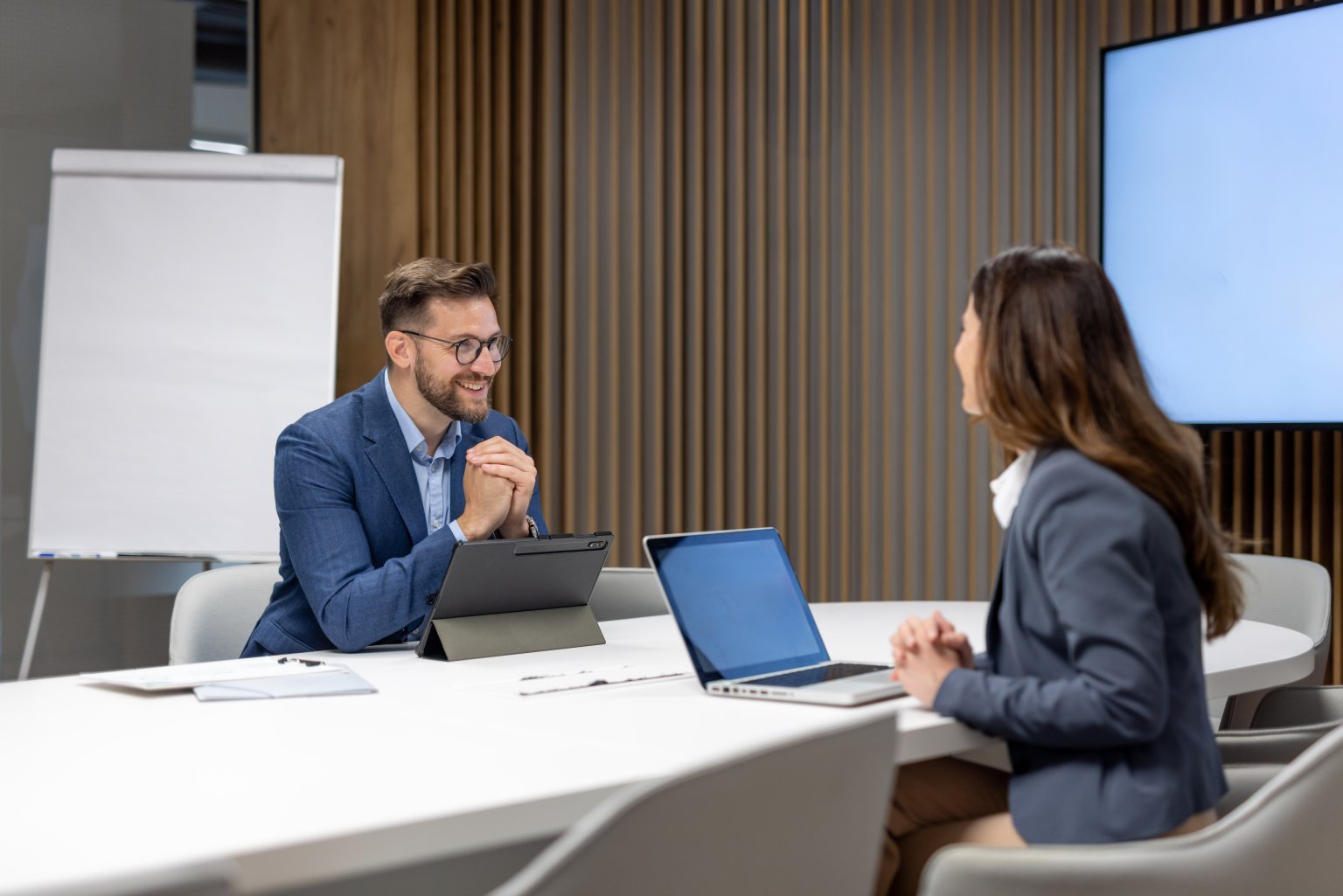 Zwei Personen im Gespräch in einem modernen Besprechungsraum der BLKB.