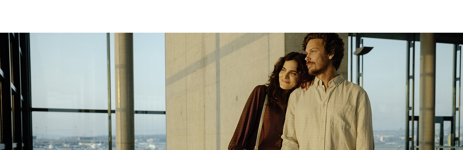 Ein Paar geniesst die Aussicht von einem modernen Gebäude mit urbaner Umgebung.