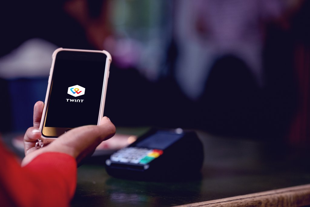 Frau bezahlt an der Kasse mit Twint