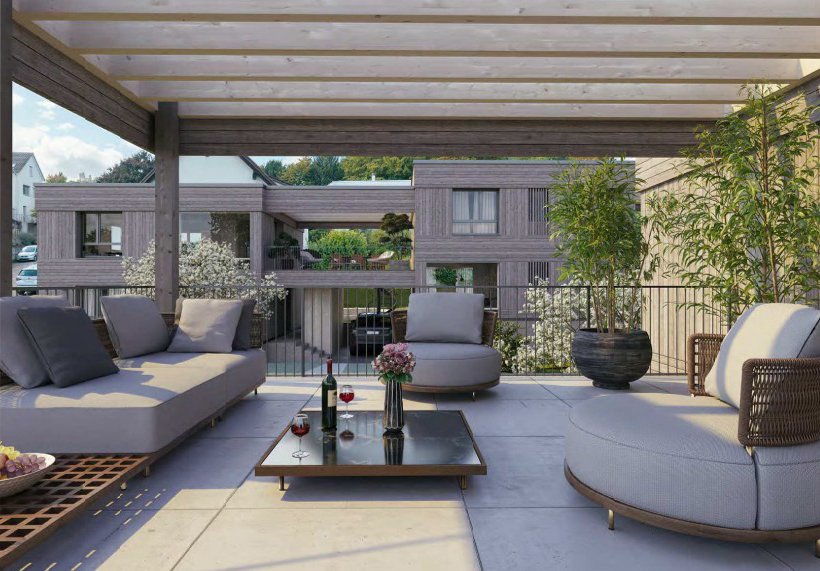 Ein Balkon mit Sitzgruppen, Pflanzen und einem Tisch mit Wein- und Obstflaschen am Brüelweg 74 - 82, 4147 Aesch.