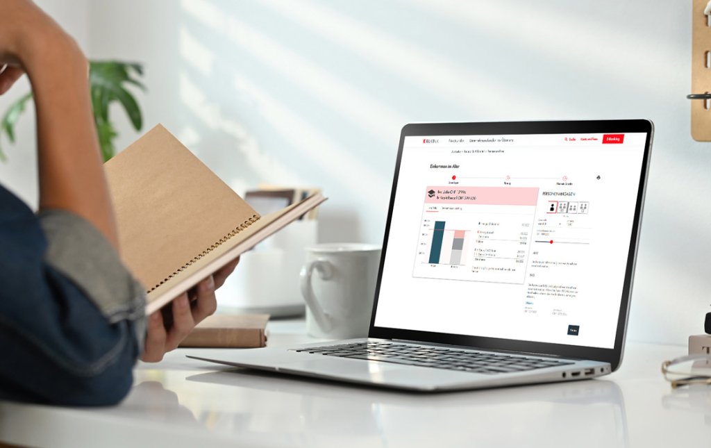 Eine Person liest in einem Notizbuch neben einem Laptop mit Bankinformationen.