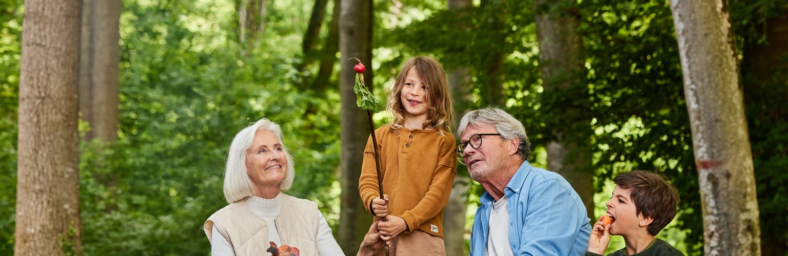 Familie am Lagerfeuer im Wald