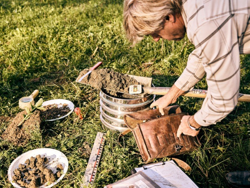 Ein Mann gräbt im Garten mit Werkzeugen und einer Blumentopf. aus dem Artikel CO₂ im Boden statt in der Luft – Zwischenbilanz