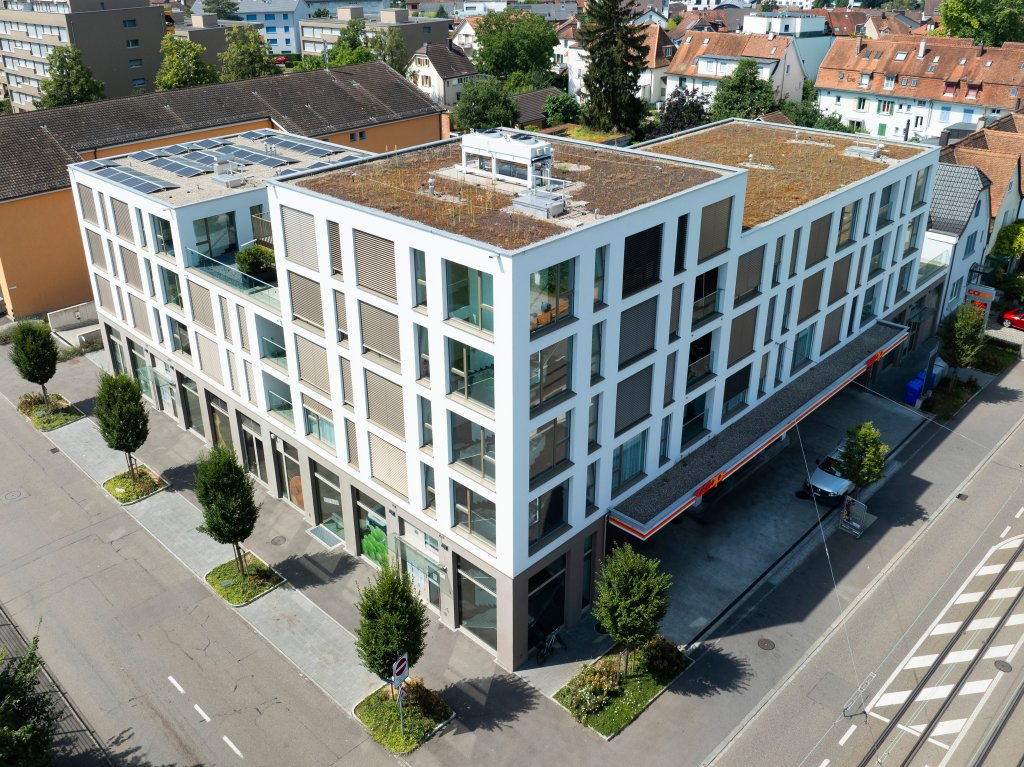 BLKB-Liegenschaft in Binningen. Modernes Wohngebäude mit grünen Dächern und städtischer Umgebung. Helles und zeitgemässes Design. aus dem Artikel