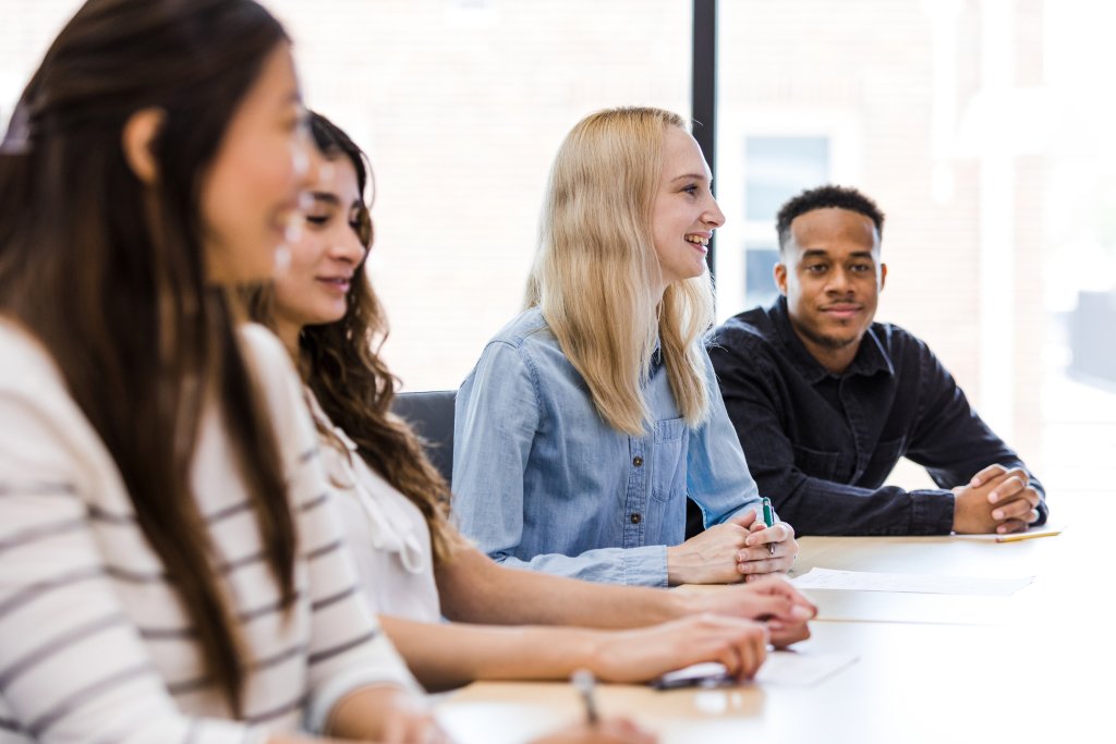 Menschen in einem Meeting diskutieren und notieren ihre Ideen aktiv.