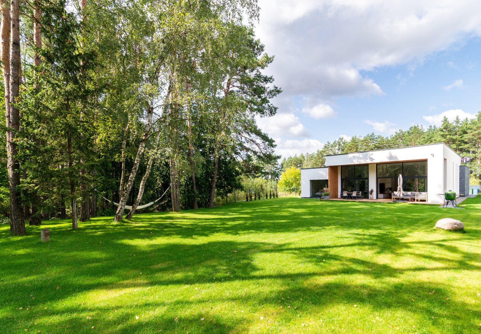 Moderne Architektur im Einklang mit der Natur, umgeben von grüner Landschaft.