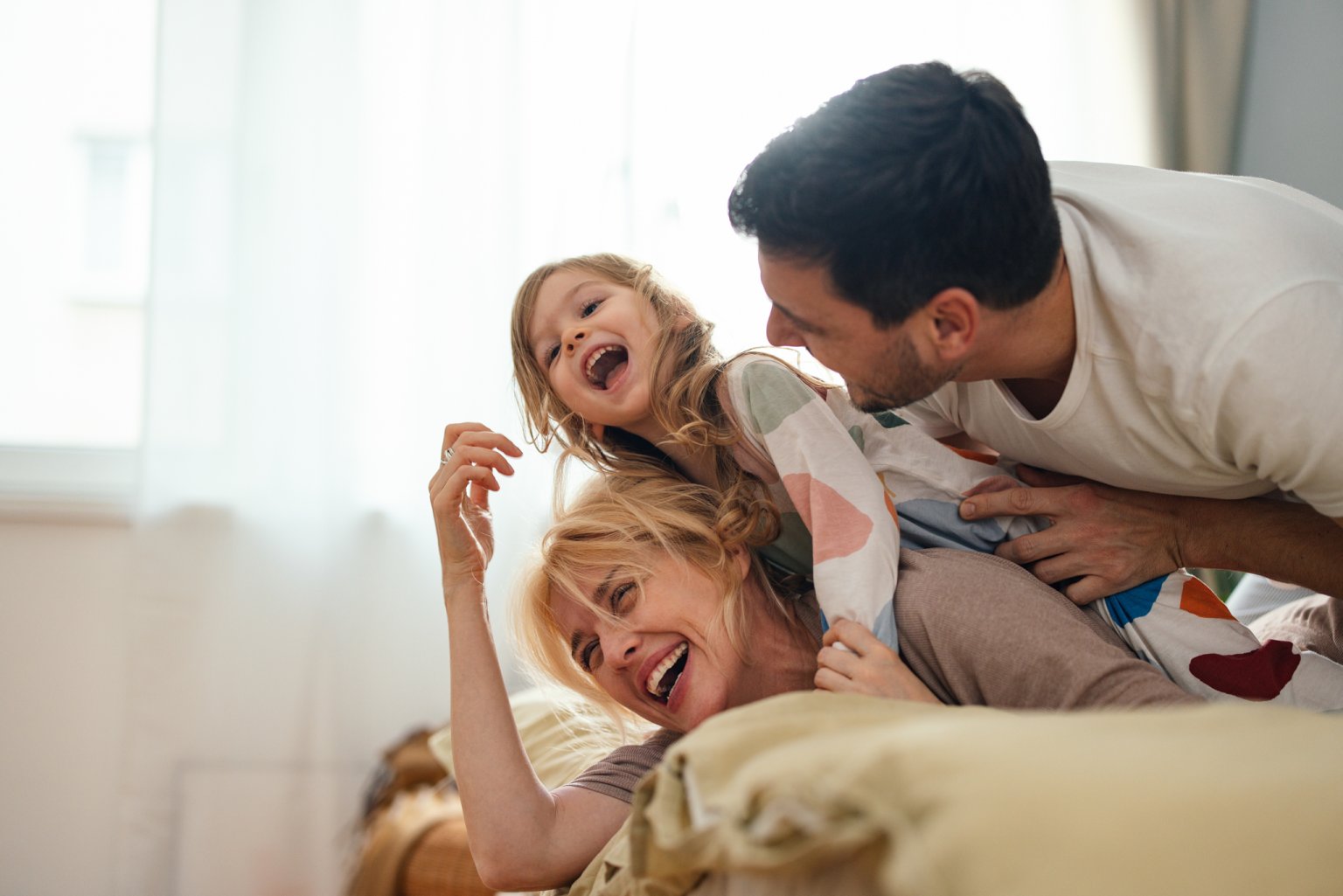 Die Familie genießt wertvolle Zeit in einer hellen, gemütlichen Umgebung. Pure Freude und Lachen. aus dem Artikel Familie absichern