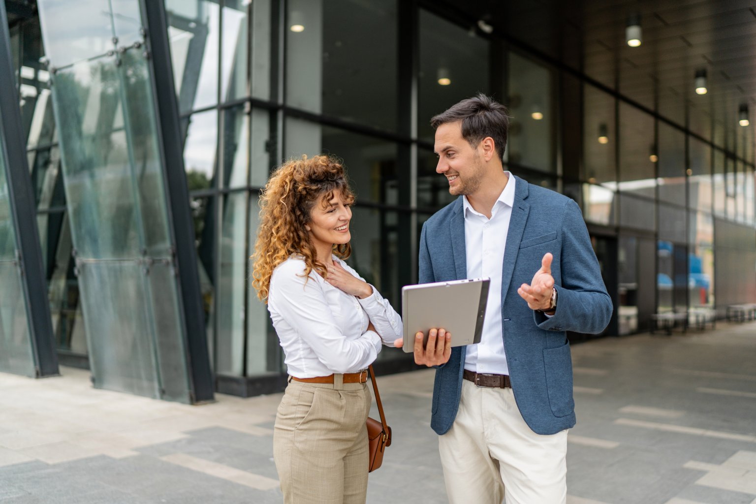 Zwei Personen im Gespräch vor dem Gebäude der Basellandschaftlichen Kantonalbank.