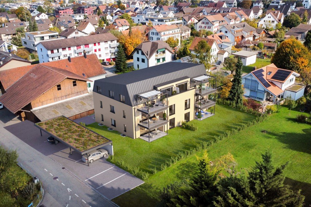 Mehrfamilienhaus in der weiten Ansicht mit Balkon und gepflegtem Garten in einer ruhigen Wohngegend am Kirchrain 1, 4107 Ettingen.