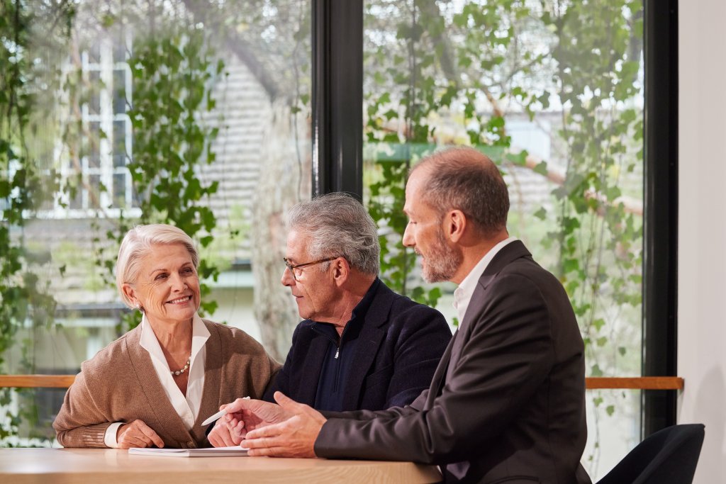 Drei Personen im Gespräch bei der Basellandschaftlichen Kantonalbank in einem modernen Raum