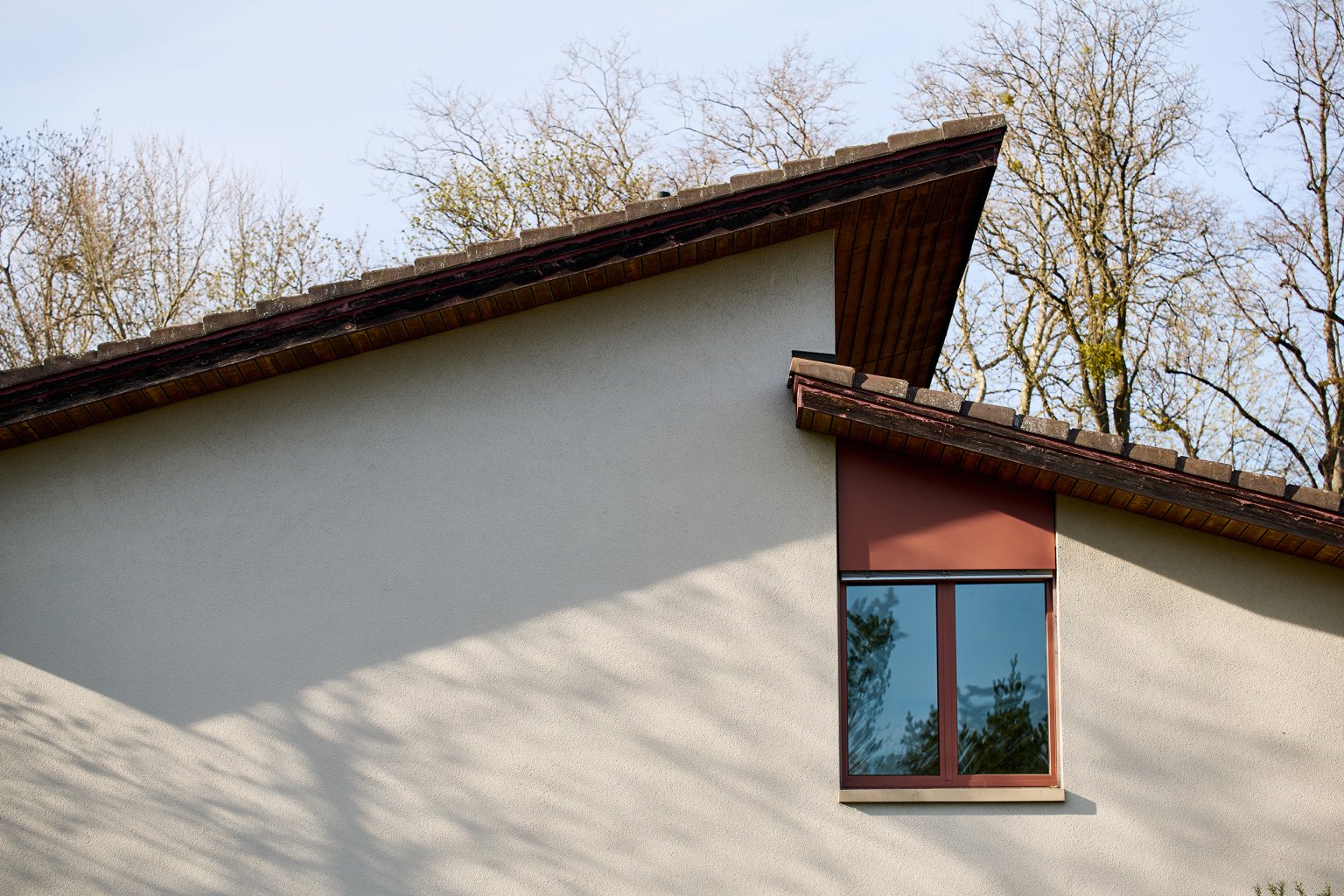 Ein Fenster unter dem Dach eines weissen Hauses. aus dem Artikel Alles für einen erfolgreichen Liegenschaftsverkauf