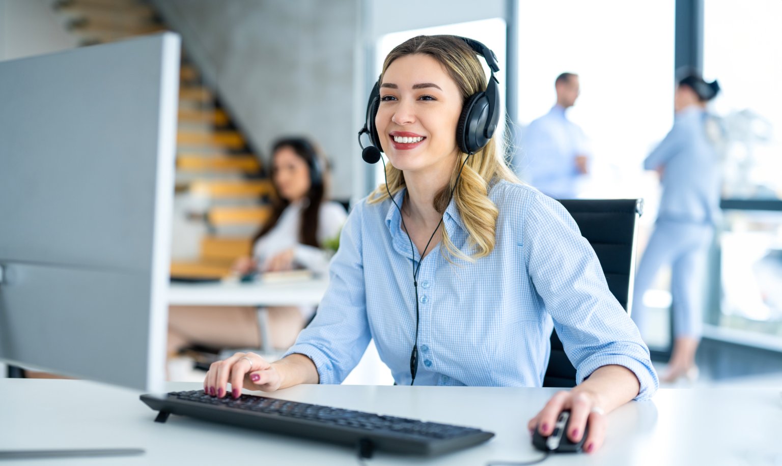 Porträt einer weiblichen Telefonistin, die in einem Callcenter bereit für Online-Hilfe ist.