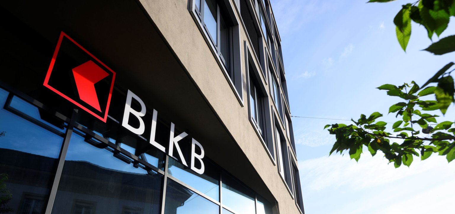 Gebäude mit grossen Fensterflächen und Logo der Basellandschaftlichen Kantonalbank BLKB an einem modernen Bürogebäude in Liestal (Hauptsitz).