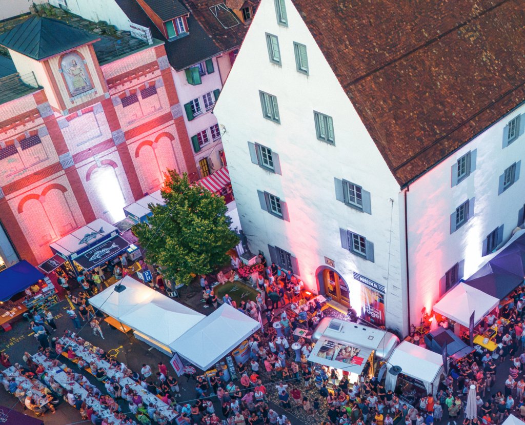 Eine belebte Strasse bei Nacht mit Marktständen und vielen Menschen für BLKB bei uns in Liestal.