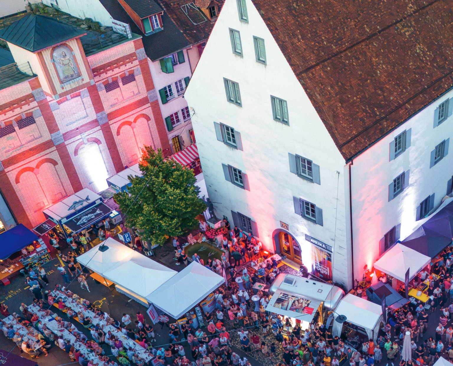 Eine belebte Strasse bei Nacht mit Marktständen und vielen Menschen für BLKB bei uns in Liestal.