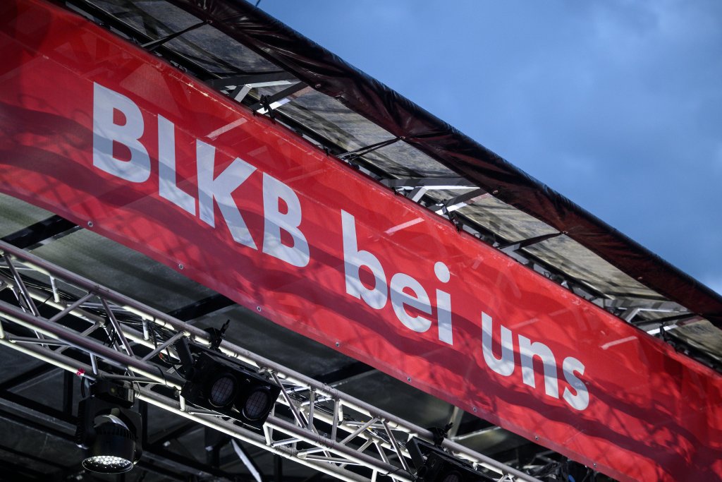 Ein Baugerüst mit rotem Banner mit weißem Text und schwarzem Himmel im Hintergrund.
