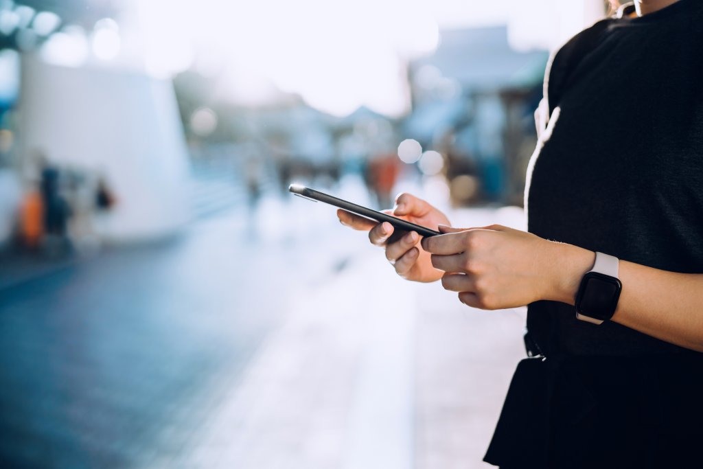 Eine Person verwendet ein Smartphone in einer städtischen Umgebung.