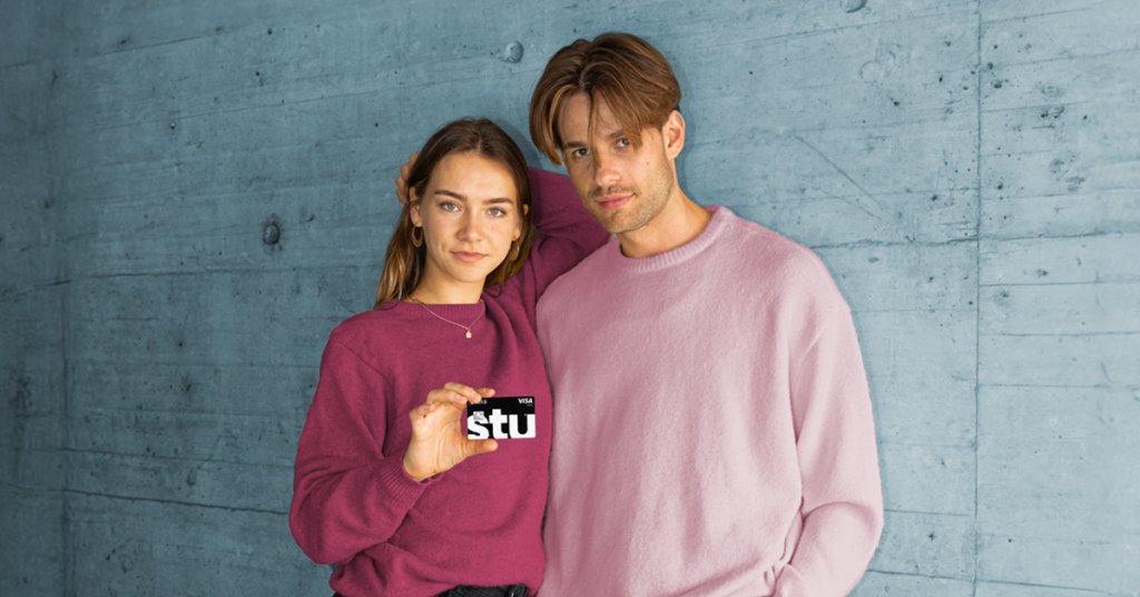 Junges Paar zeigt stolz ihre BLKB Karte vor einem modernen Hintergrund.