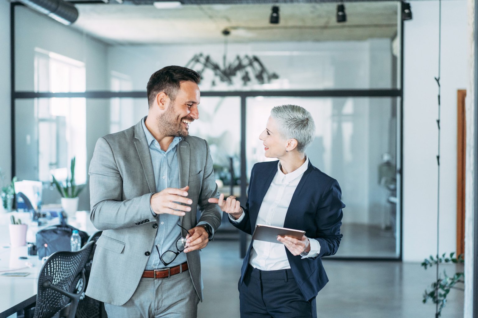 Zwei Personen in einem modernen Büro sprechen miteinander.