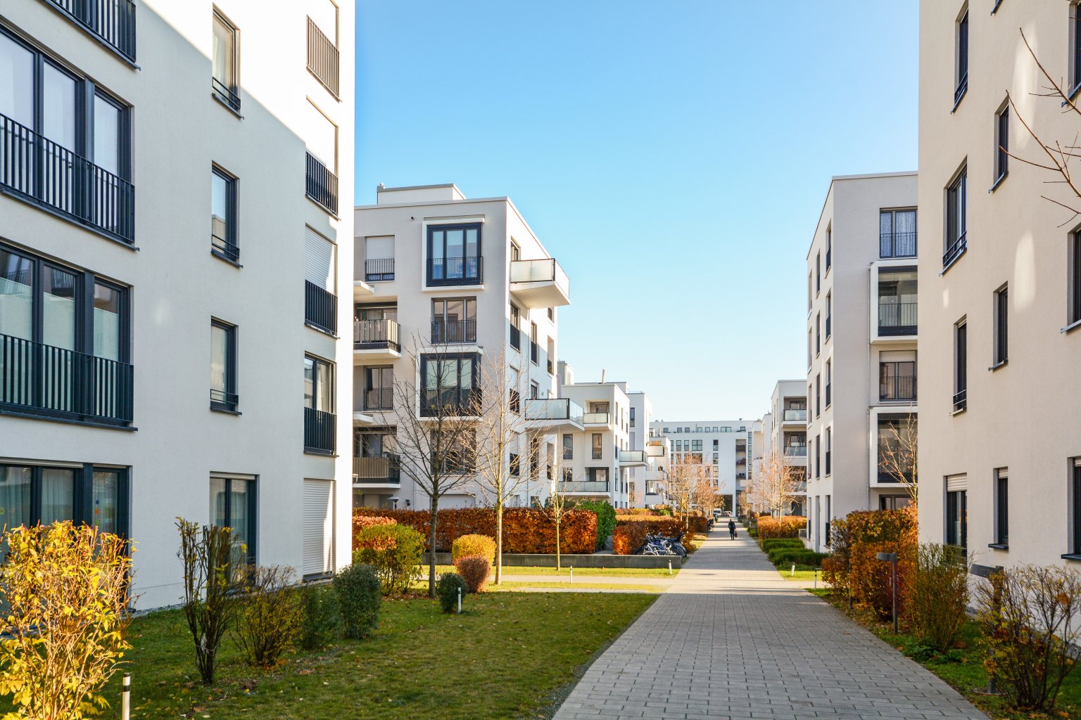 Moderne Wohnanlagen mit gepflegtem Garten und breitem Fussweg.